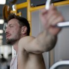 Muscular man exercising on gym equipment, demonstrating strength and focus in a fitness environment.